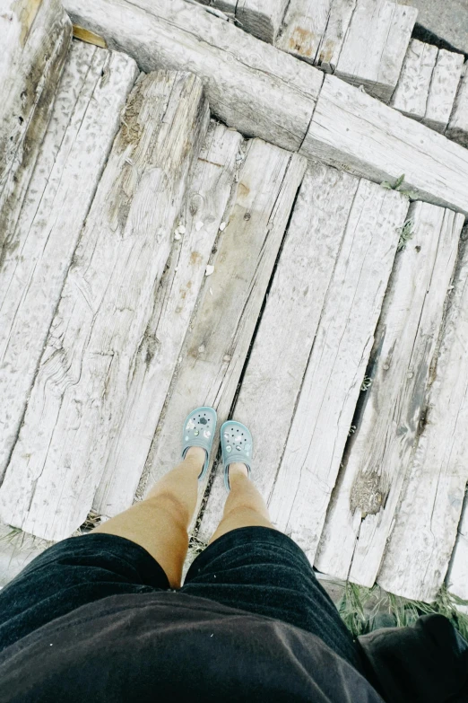 a person's feet in front of a wooden door