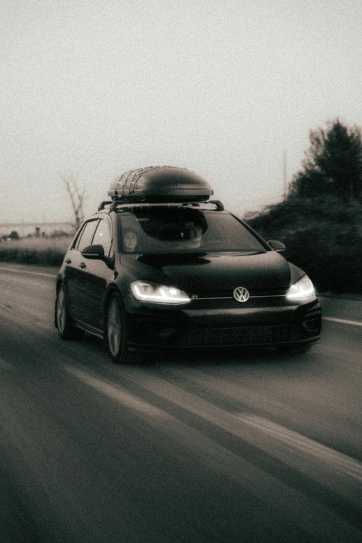 a vw hatchback in the middle of a road