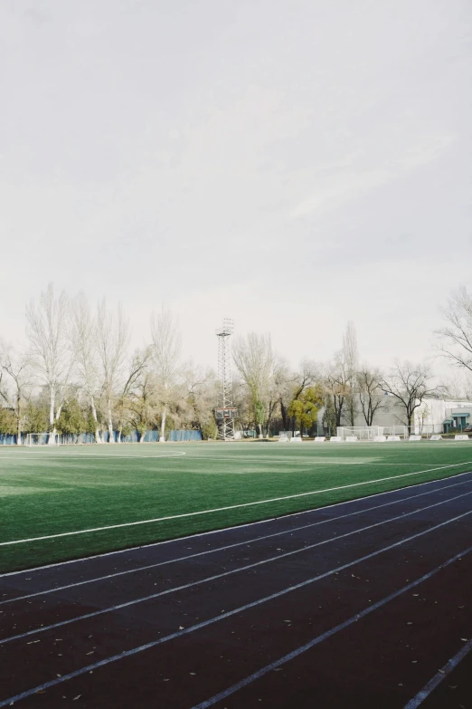 a field with a soccer ball next to the fence