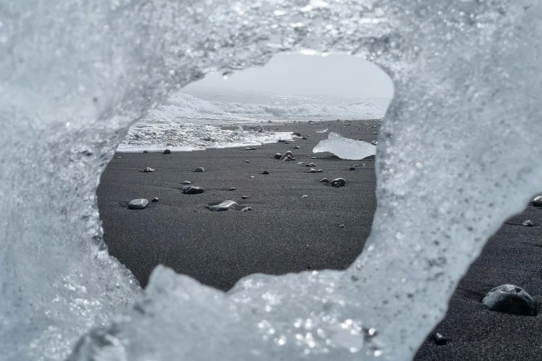 ice chunks and bubbles in the water with a hole inside it