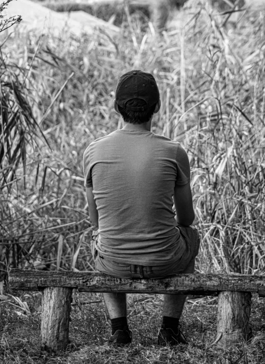 black and white pograph of a man sitting on a bench