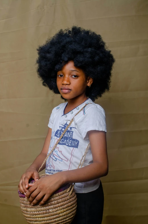 a child wearing a white t - shirt with an afro