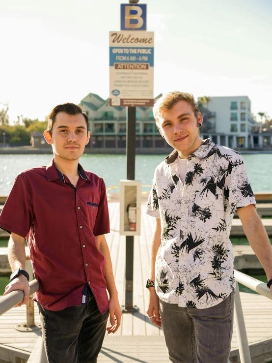 two men standing on a wooden dock near water