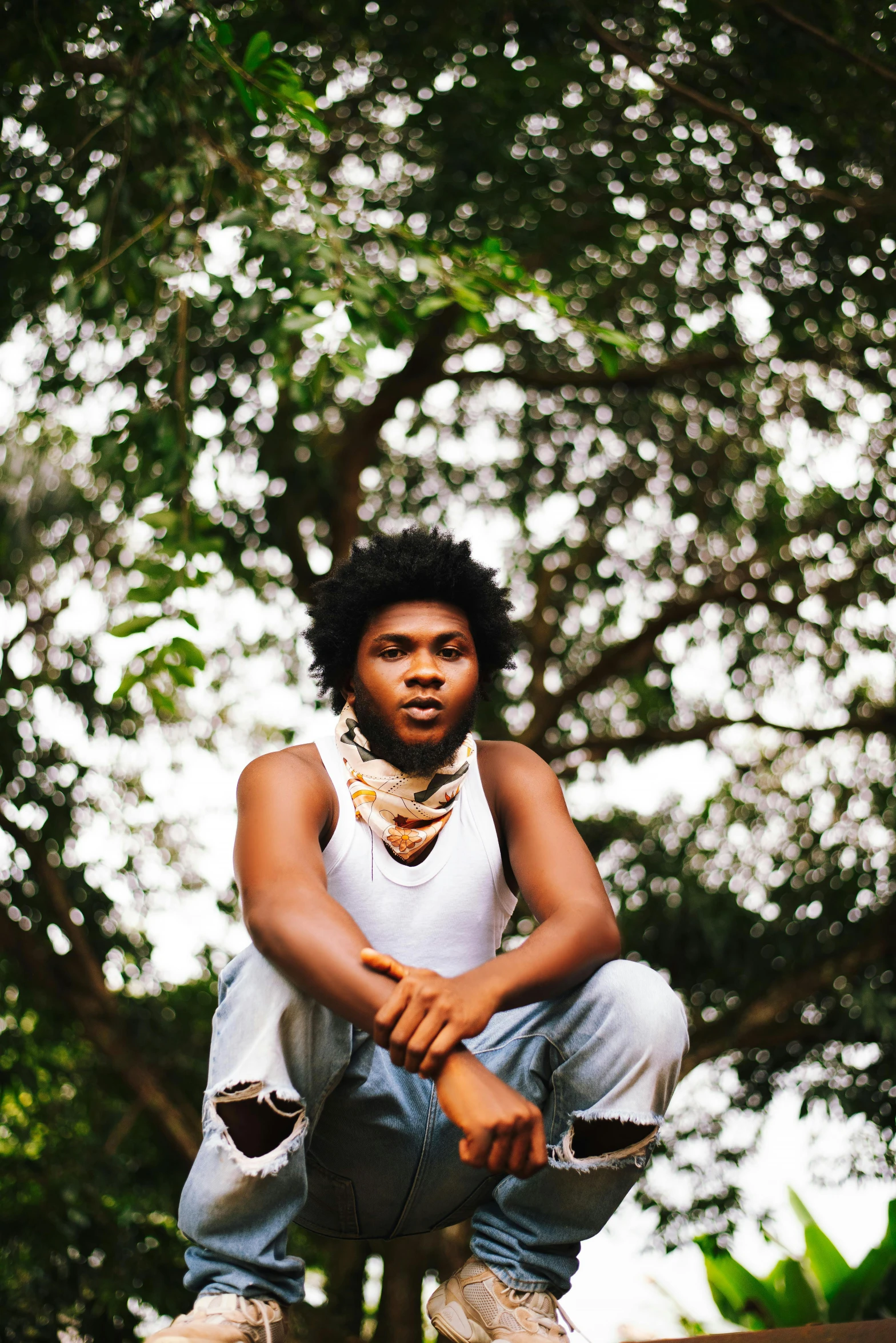 an african american boy sitting on steps wearing a white shirt and jeans