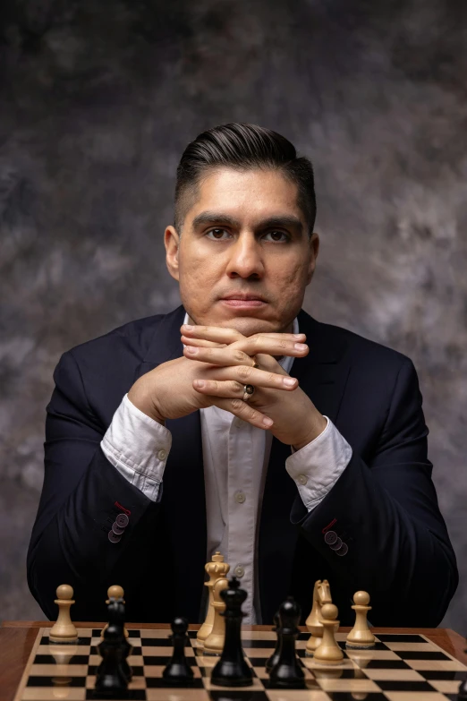 a man sitting at a table with his hand on a chessboard