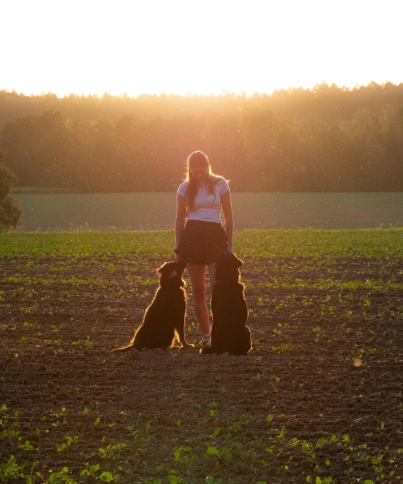 two women are in a field with a dog