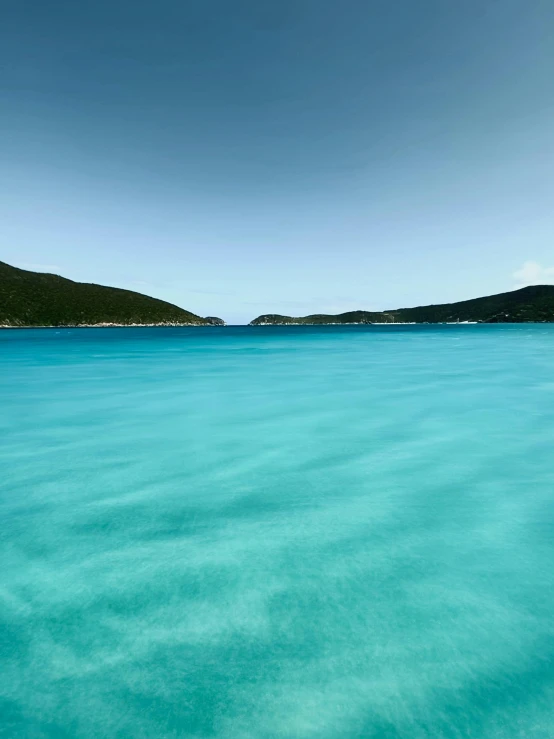 blue water is shining bright on the beach