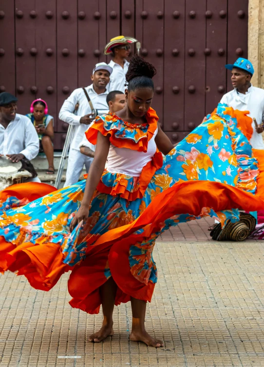 an african dancer in a colorful dress is dancing around
