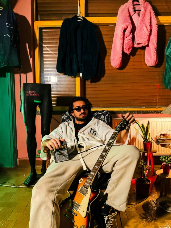 a man sitting on a chair holding a guitar