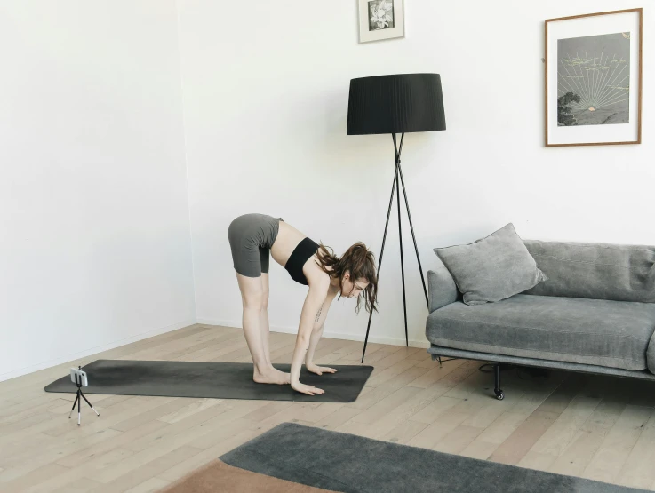 woman in a gray outfit on her yoga mat