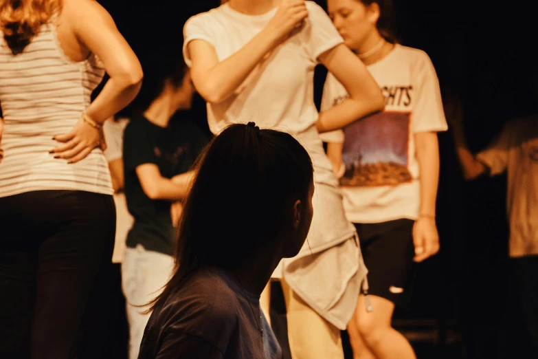 a woman standing next to a group of people on a stage