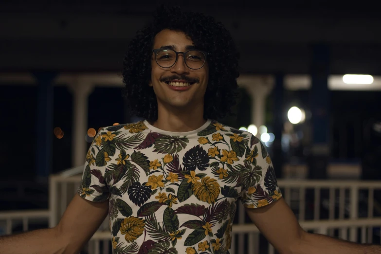 a person with long hair wearing a flower shirt