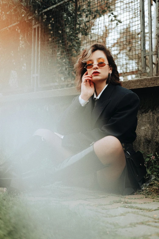 a woman in black jacket and boots sits on steps