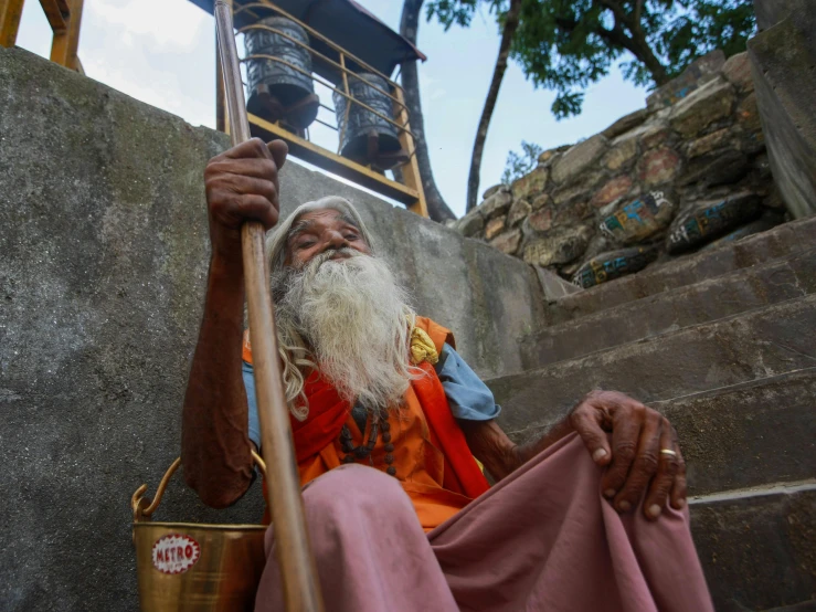 old man with a white beard and long white hair holding an instrument