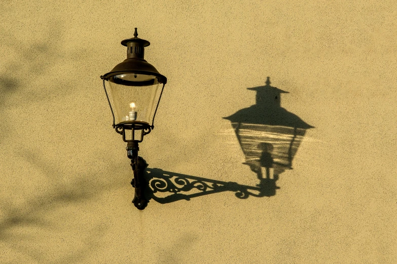 a lamp hanging off the side of a wall next to a street