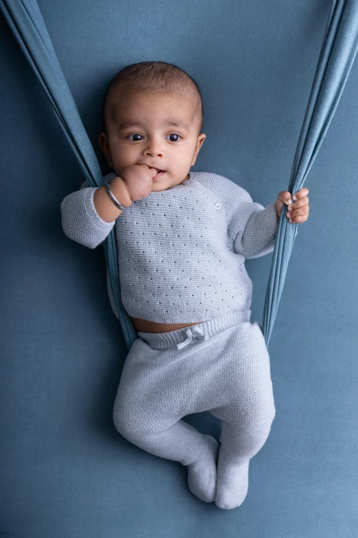 a baby laying on top of a blue carpet