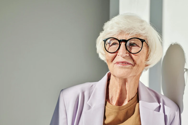 an elderly lady is sitting and looking at the camera