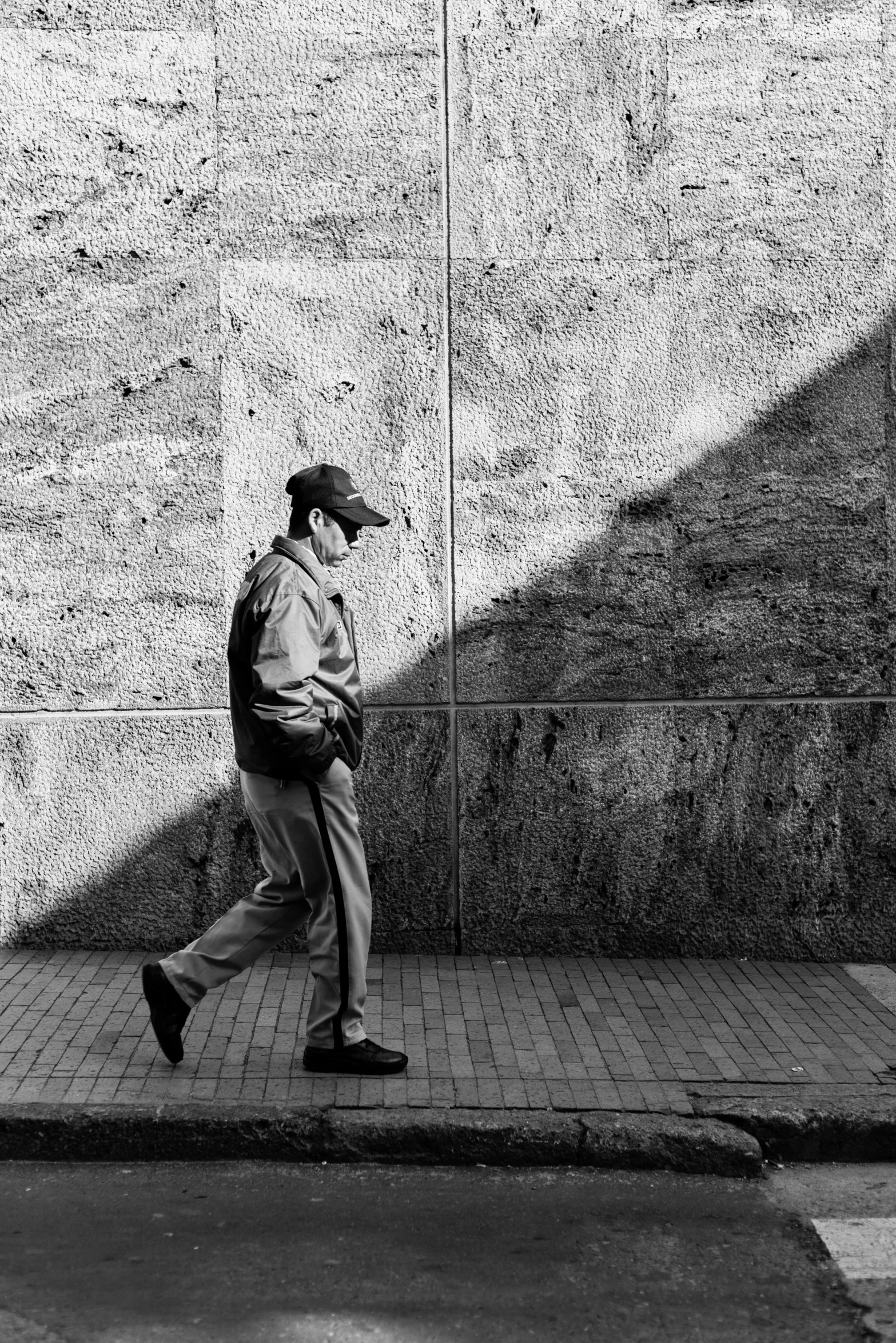 a man walking down a sidewalk with a book bag