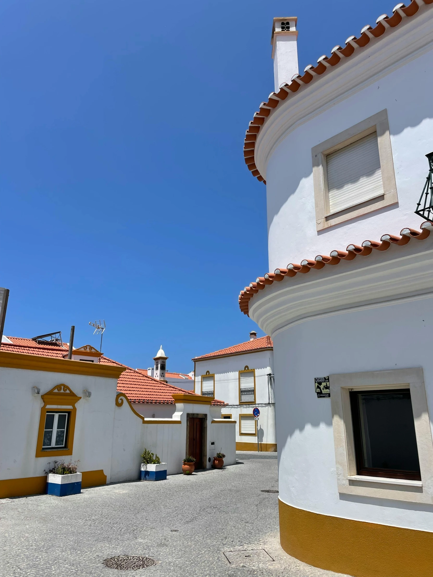 this is a white and tan building with red tile