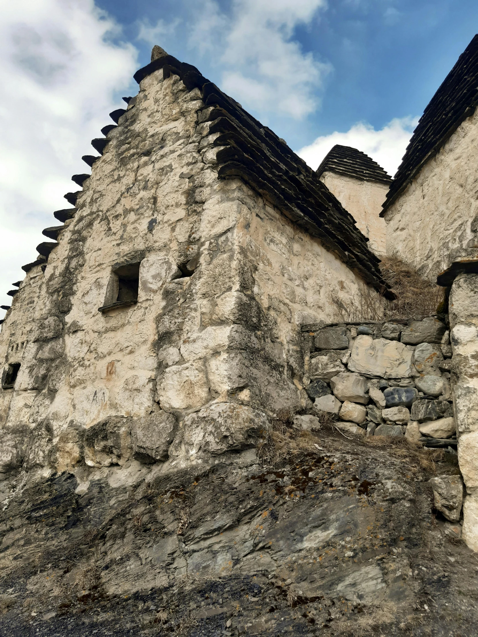 a large stone structure with several windows is up against the sky