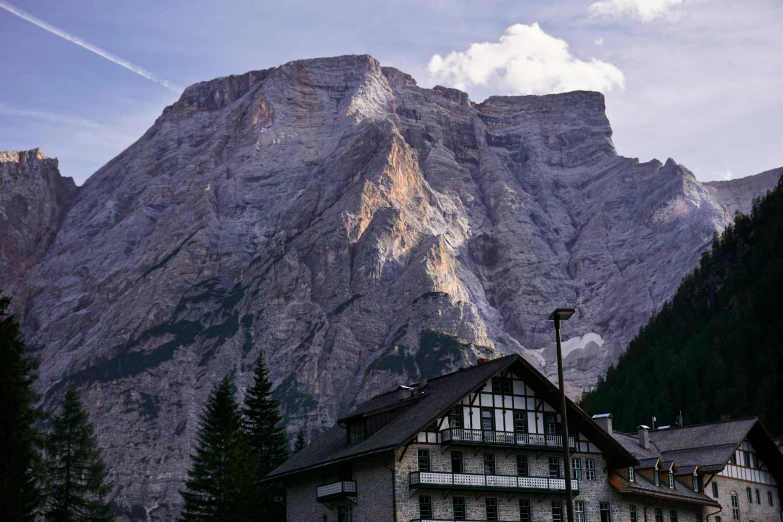 a tall mountain next to a forest filled with trees