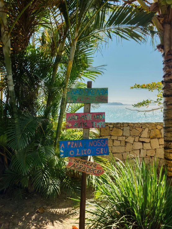 the colorful signpost has many different signs hanging from it