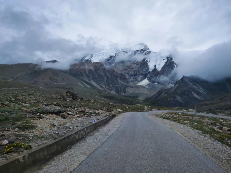 road next to mountain with snow capped mountains