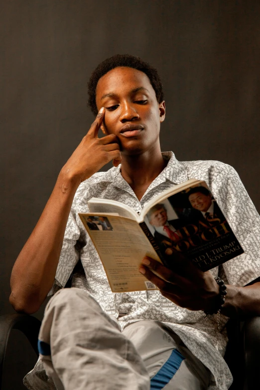 a man is holding his head up with a book in his hands