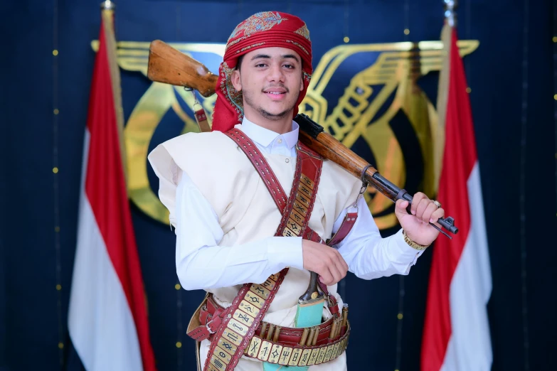 a person is posing with a pole while wearing a turban and a vest