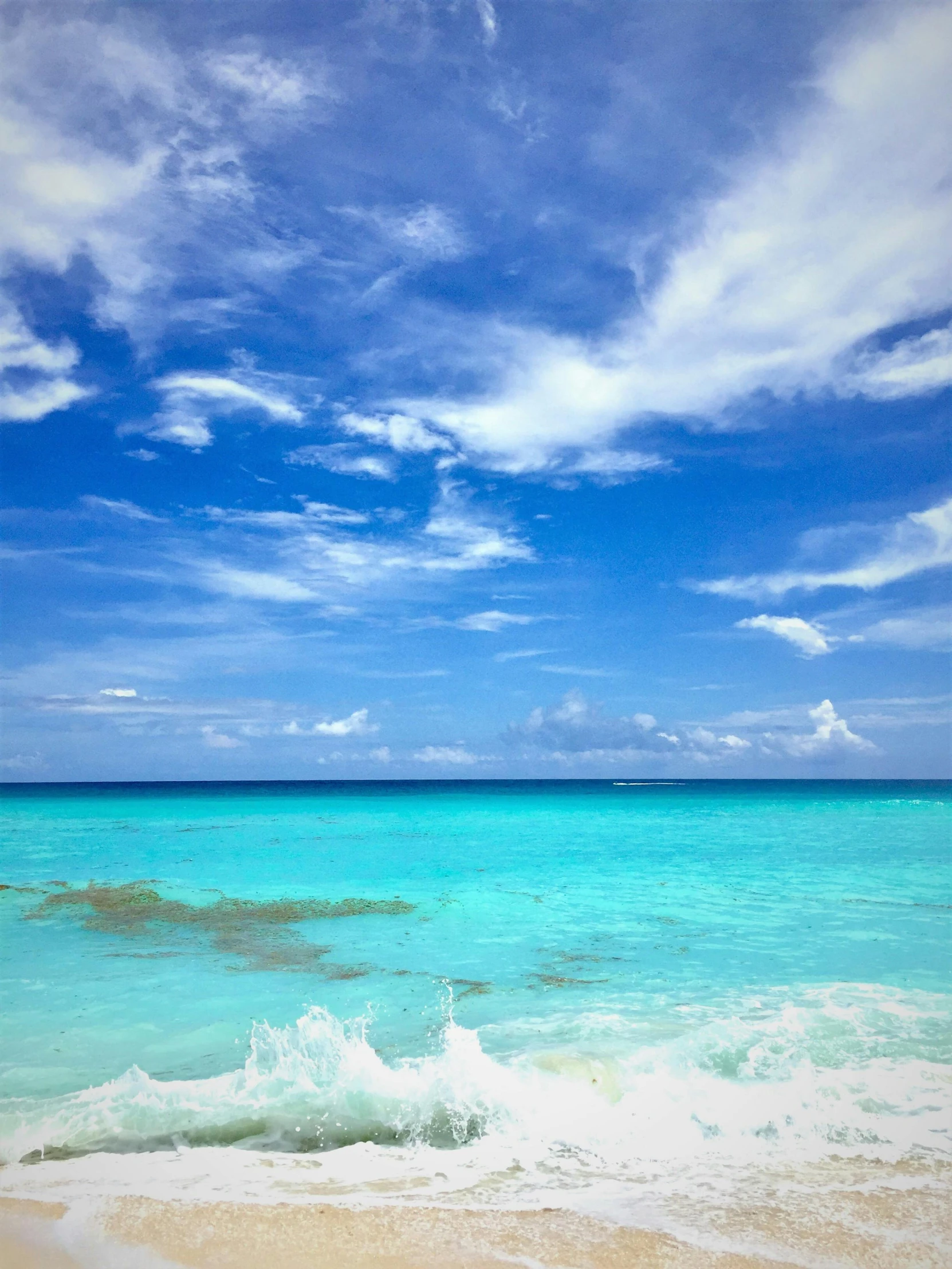 some water waves and a beach and clouds