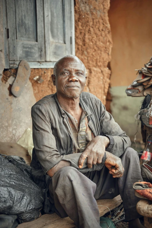 an older man sits in front of his home