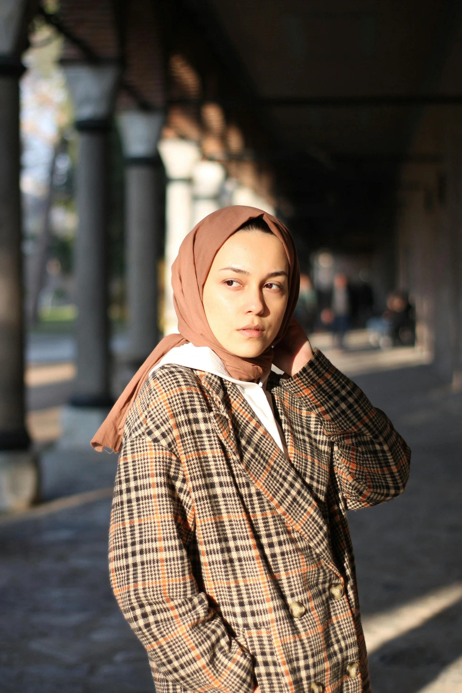 woman standing on street with a headscarf over her shoulder