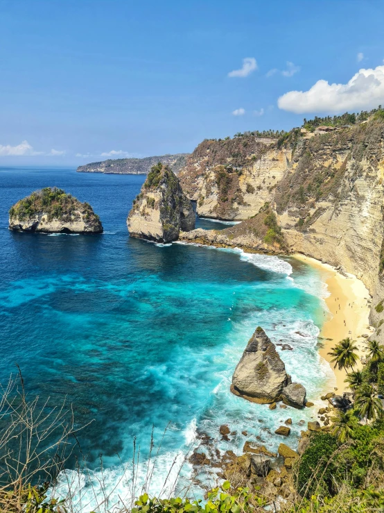 an empty beach is pictured with rocks and a rock formation