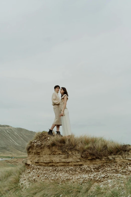 couple standing on the edge of grass in an open field