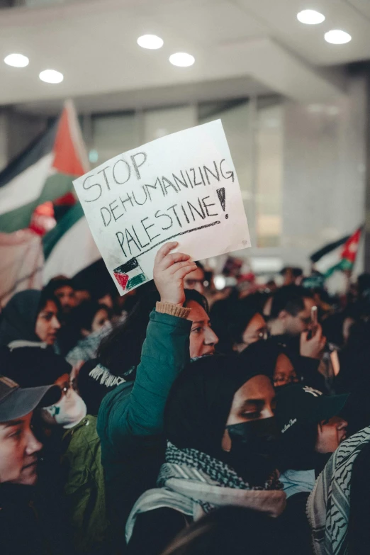 a group of people in a large room holding protest signs