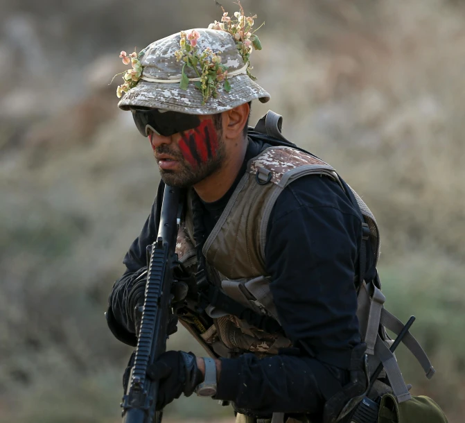 a man with a paint face and hat holds a gun