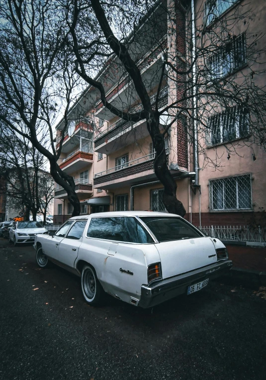 an old car is parked outside the apartment buildings