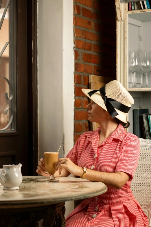 a woman wearing a hat while sitting in a booth