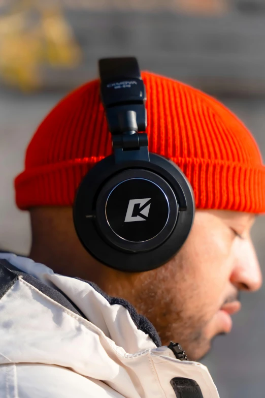 a man in an orange hat is wearing black headphones