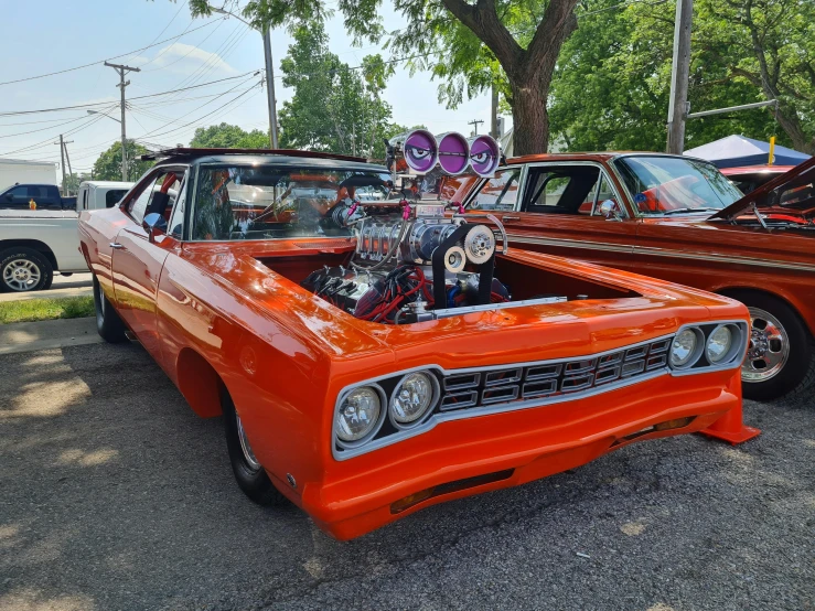 the orange car is parked near other cars