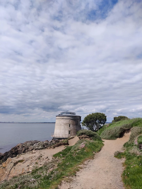 a walkway that leads to a lighthouse on the side of a lake