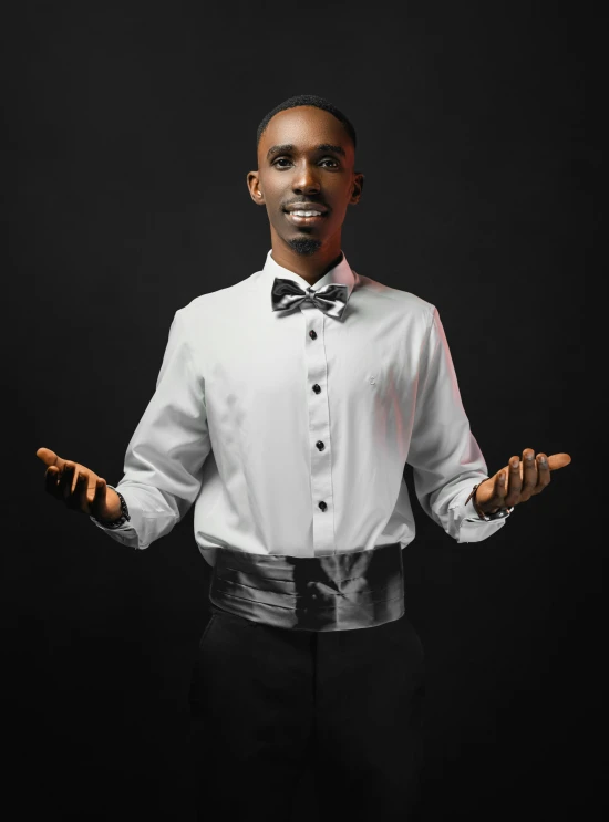 a male in a white shirt and black bow tie