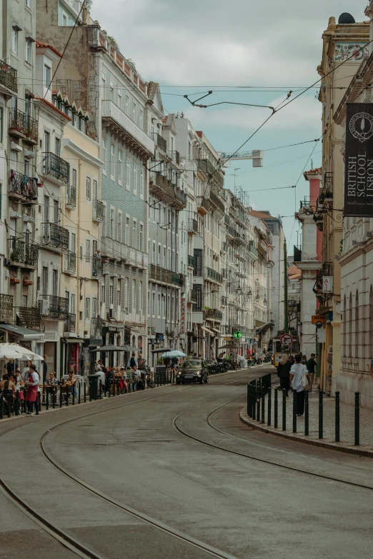 a line of buildings with people standing on the sidewalk below