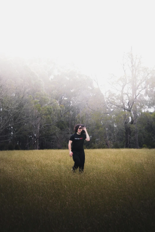 the person is standing in a field and holding a camera up