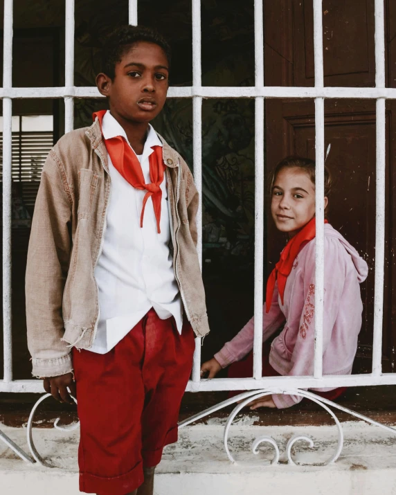 two children standing in front of a window