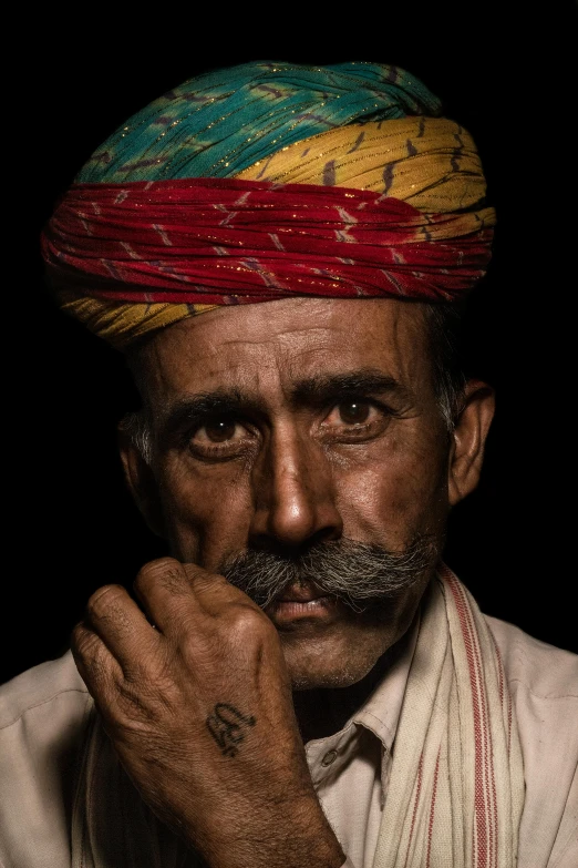 a man with a colorful headband and tattoo on his arm