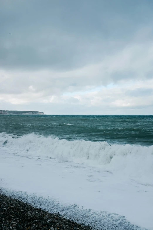 a person walking on a beach next to the ocean