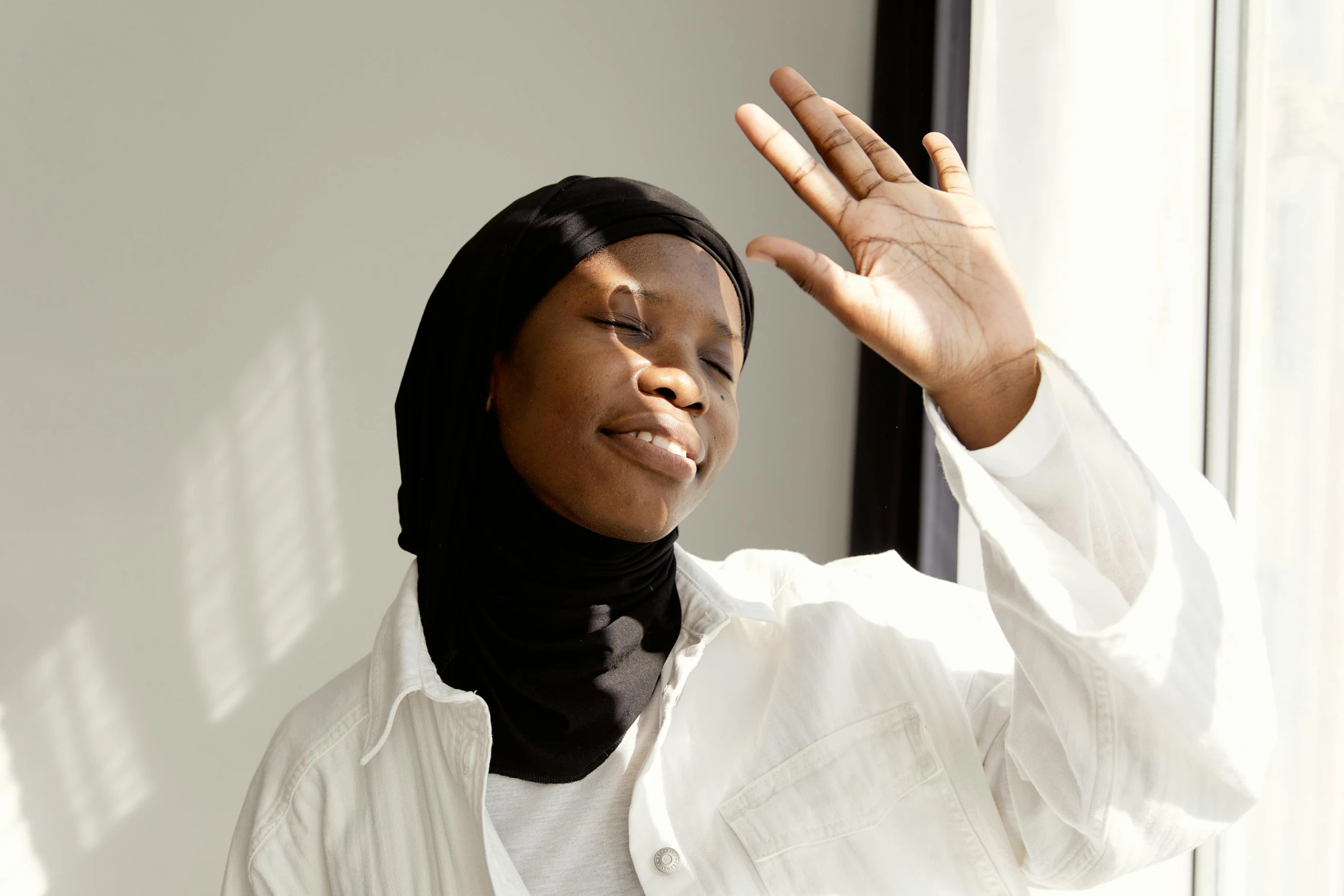 a close up of a person with her hand up