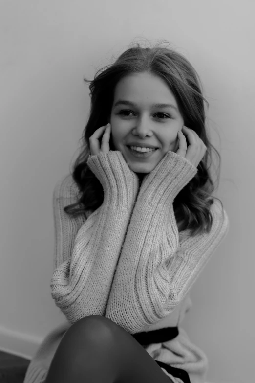 a girl posing with her hands behind her ears