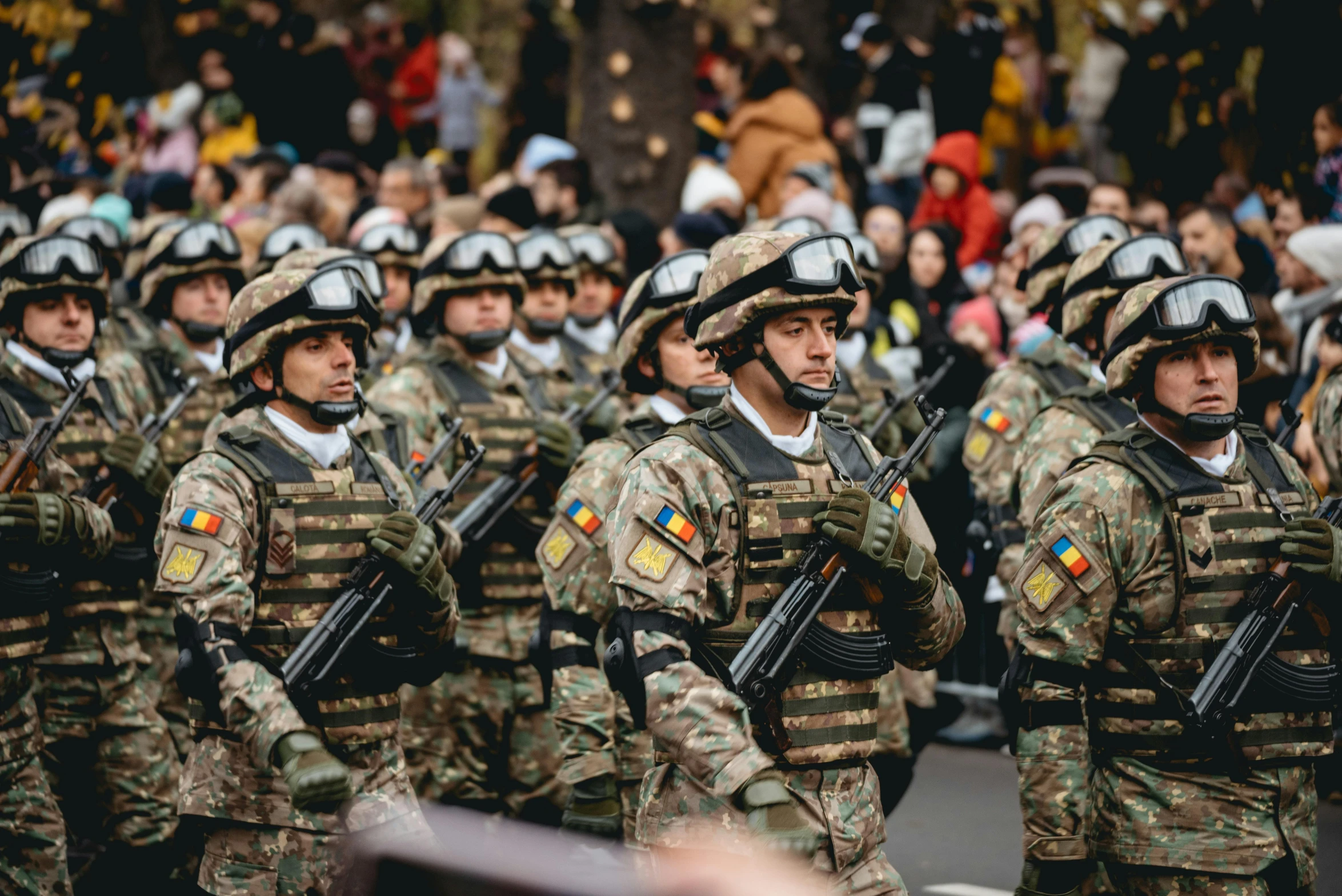 men in camouflage uniforms stand in a line at a parade